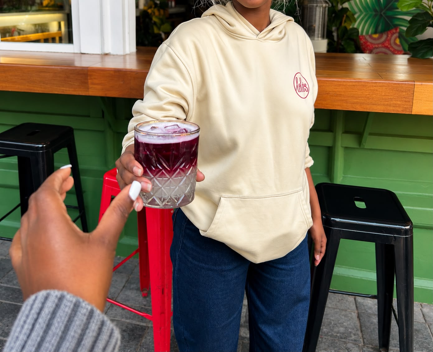 Two guests toasting berry cocktails at the pavement bar